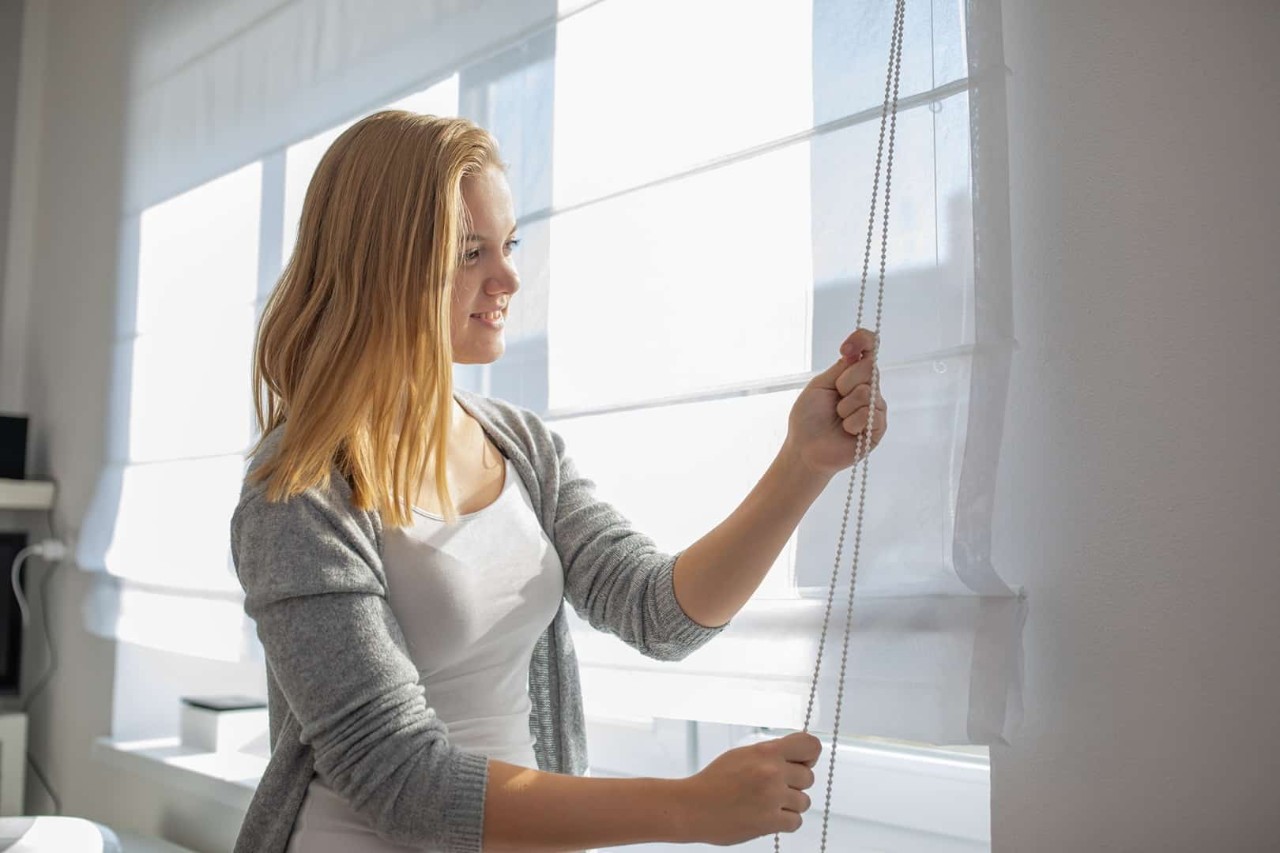 Image of a person using a cordless window treatment in their home