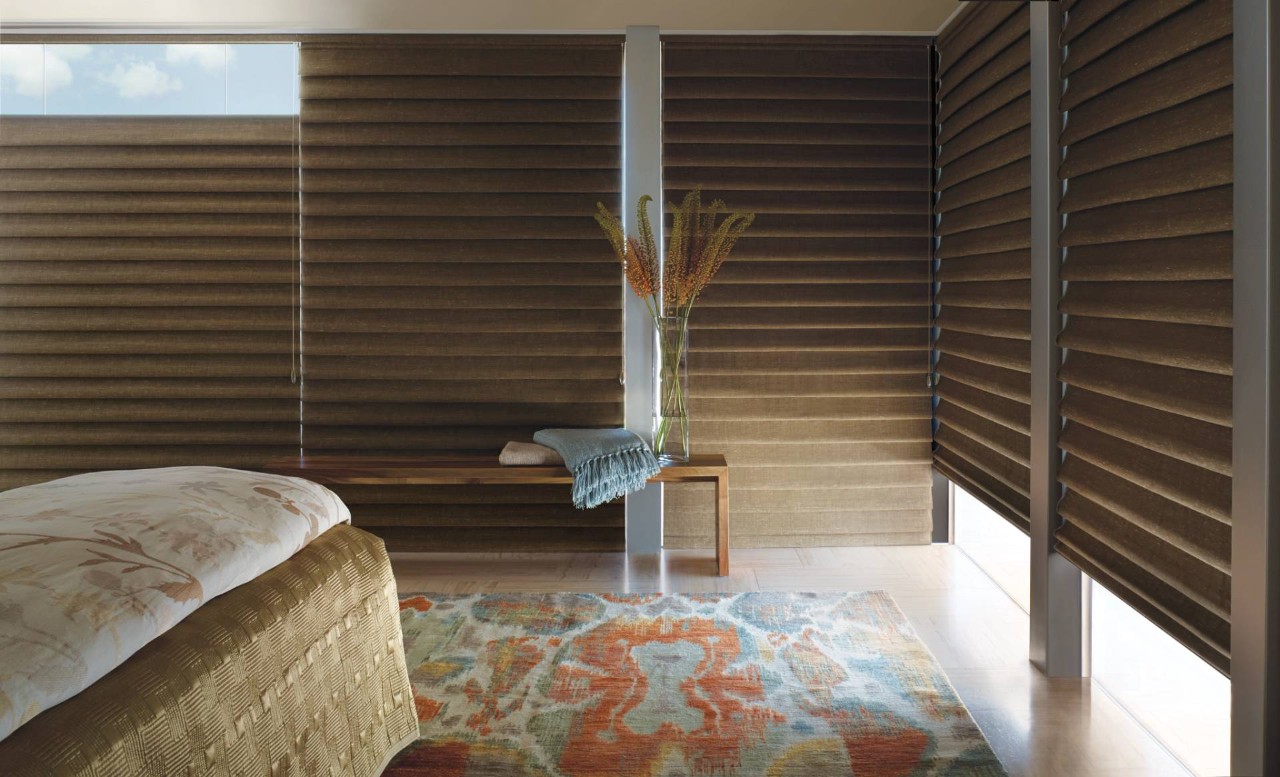 Bedroom with dark brown Hunter Douglas Vignette® Roman Shades blocking the incoming sunlight near Alpharetta, GA